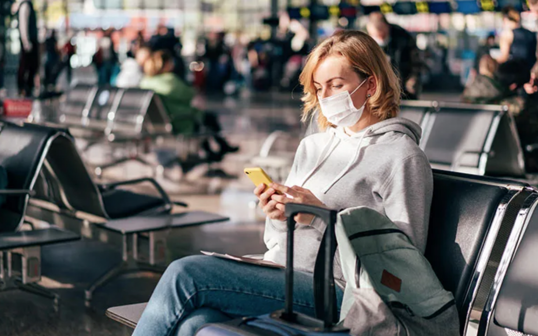 woman sitting at airport wearing a mask
