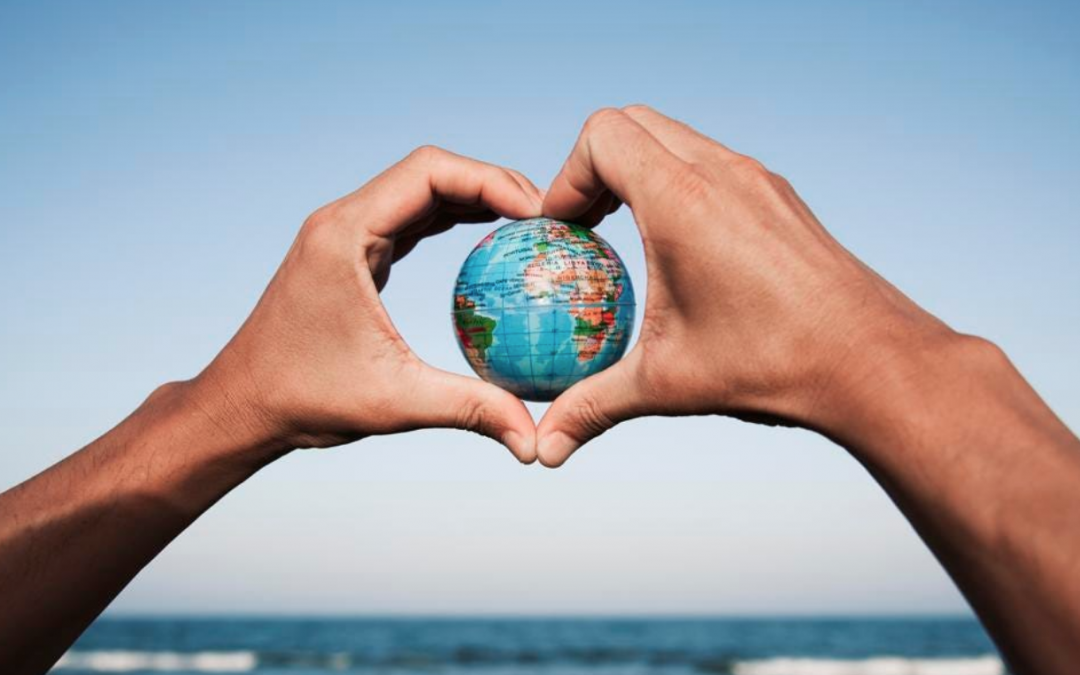 Two hands holding a globe between them
