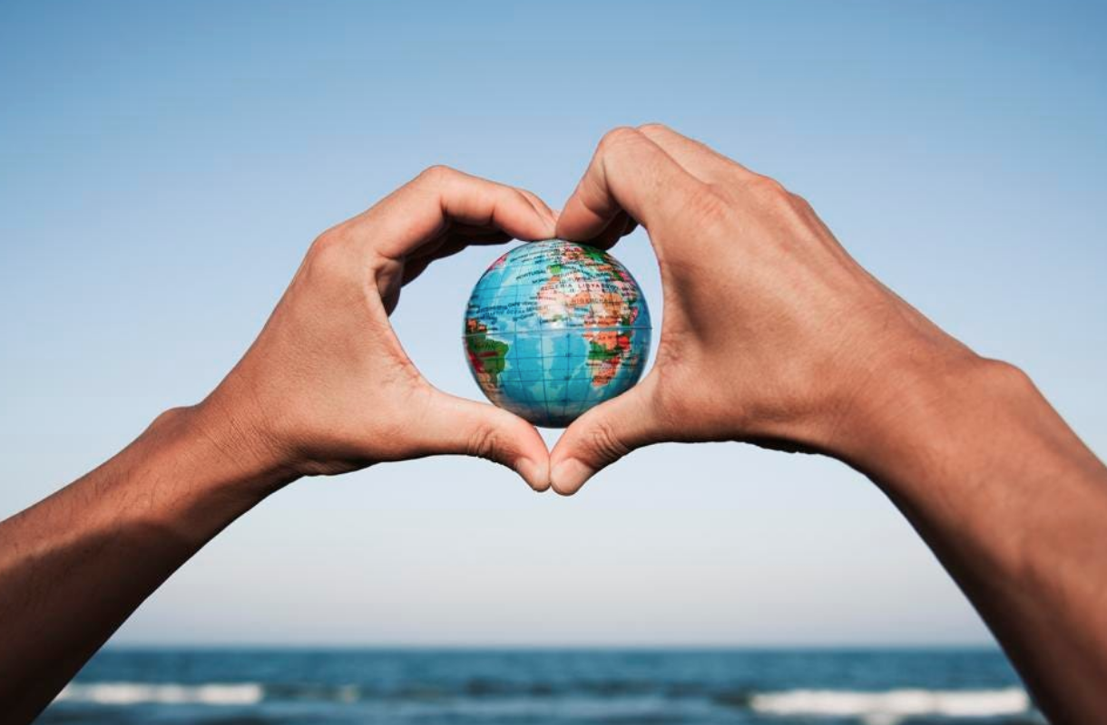 Two hands holding a globe between them